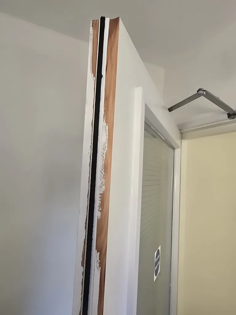 Door frame with exposed timber and fire stopping material visible during installation work