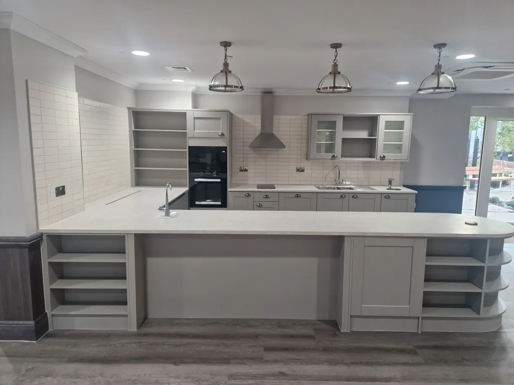 Modern fitted kitchen with large island counter, open shelving, wall cabinets and pendant lighting